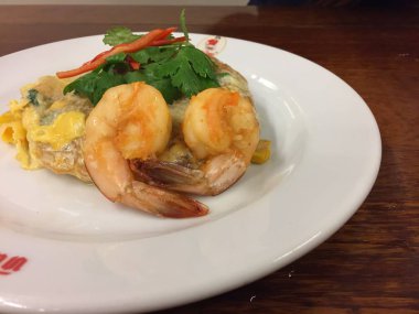 Tayland usulü kızarmış şehriye (pad Thai), bu sokak yemeği ve Bangkok, Tayland 'ın en ünlüsü, ahşap bir masada siyah bir tabakta lezzetli ve güzel olmak isteyen açlığa neden oluyor.