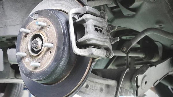 波纹车排气系统在浅景深和盘式制动器的车辆维修 在新轮胎更换过程中 汽车刹车修理在车库 — 图库照片