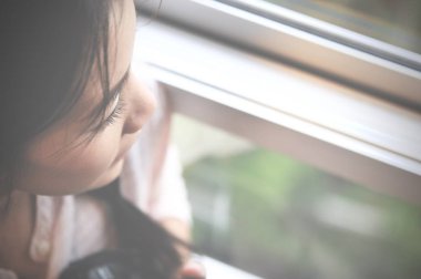 İyi günler! Sabah ve pencere oturmak ve hayal ederken bir mutluluk sahip genç akıllı başarılı gülümseyen kadın kapatmak.