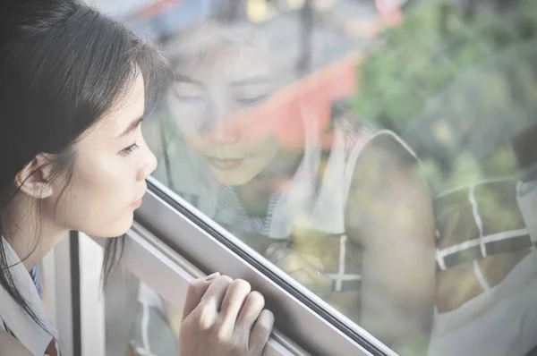 İyi günler! Sabah ve pencere oturmak ve hayal ederken bir mutluluk sahip genç akıllı başarılı gülümseyen kadın kapatmak.