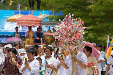 Lopburi, Tayland - 18 Mayıs 2019 - Tayland Budist heykeli büyük Buda heykeli ve elinde yanan mum ve yılbaşı günü tapınakta dolaşan nilüfer çiçeği. Girdap. Budist kutsal günü. Erdem gösteriyorum..