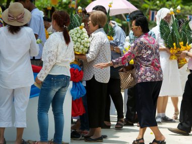 Lopburi, Tayland - 18 Mayıs 2019 - Tayland Budist heykeli büyük Buda heykeli ve elinde yanan mum ve yılbaşı günü tapınakta dolaşan nilüfer çiçeği. Girdap. Budist kutsal günü. Erdem gösteriyorum..