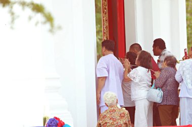 Lopburi, Tayland - 18 Mayıs 2019 - Tayland Budist heykeli büyük Buda heykeli ve elinde yanan mum ve yılbaşı günü tapınakta dolaşan nilüfer çiçeği. Girdap. Budist kutsal günü. Erdem gösteriyorum..