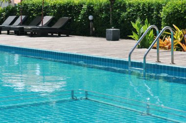 Yüzme havuzunda bir bar merdiveni, temiz su ve deniz manzaralı mavi bir spa yüzme havuzu..