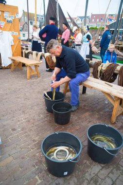 Urk, Hollanda - 19 Mayıs 2018: yılan balığı yıllık Urker günlerde temizlik bilinmeyen bir adam. Ülkenin en büyük balıkçı filosu ile en çok tanınan balıkçı köyleri, Urk açıktır.