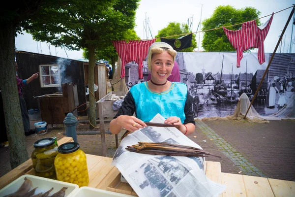 ウルク オランダ 2018 Urker 日うなぎの燻製未知の女性の伝統的な衣服を販売します ウルクは最大の漁船団を持つ国で最も有名な漁村の — ストック写真