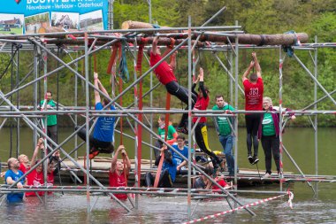 Oldenzaal, Hollanda - 7 Mayıs 2017: Bilinmeyen sporcuların bir su birikintisi tırmanma çerçevede çalıştırmak bir hayatta kalma sırasında tırmanma meşgul