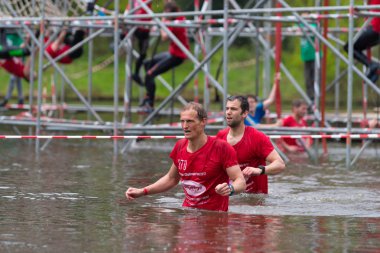 Oldenzaal, Hollanda - 7 Mayıs 2017: sığ bir göl çalıştırmak bir hayatta kalma sırasında yürüyüş bilinmeyen sporcular