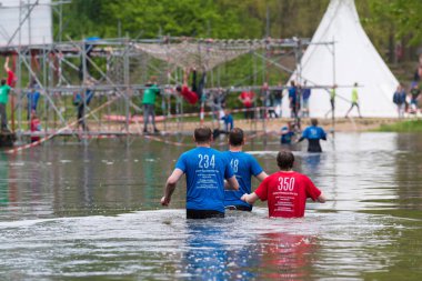 Oldenzaal, Hollanda - 7 Mayıs 2017: sığ bir göl çalıştırmak bir hayatta kalma sırasında yürüyüş bilinmeyen sporcular
