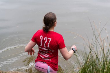 Oldenzaal, Hollanda - 7 Mayıs 2017: sığ bir göl çalıştırmak bir hayatta kalma sırasında yürüyüş bilinmeyen sporcular