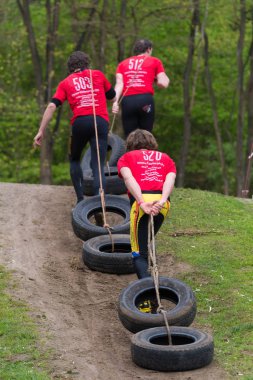 Oldenzaal, Hollanda - 7 Mayıs 2017: çalıştırmak bir hayatta kalma araba lastikleri çekerek bilinmeyen sporcular