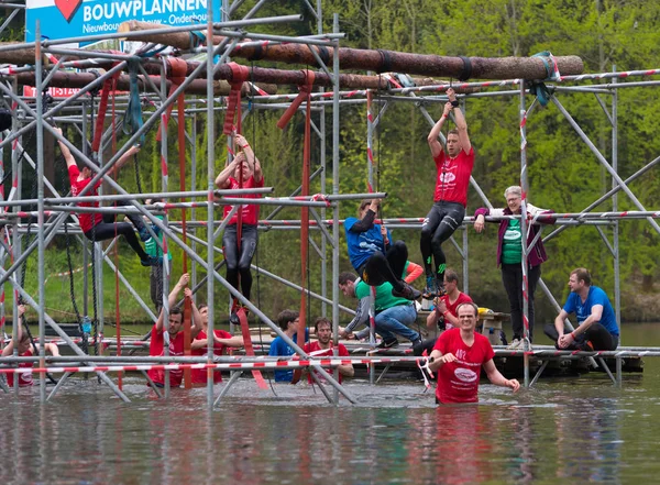 Oldenzaal, Hollanda - 7 Mayıs 2017: Bilinmeyen sporcuların bir su birikintisi tırmanma çerçevede çalıştırmak bir hayatta kalma sırasında tırmanma meşgul