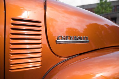 Nijverdal, Hollanda - 17 Eylül 2017: Bir portakal kahverengi oldtimer araba chevrolet logosuna Closeup.