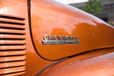 Nijverdal, Hollanda - 17 Eylül 2017: Bir portakal kahverengi oldtimer araba chevrolet logosuna Closeup.