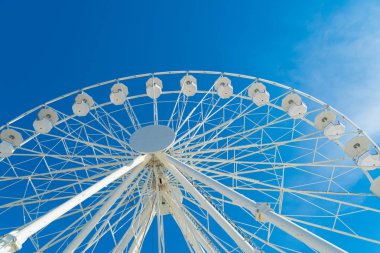 Beyaz bir dönme dolap güneşli mavi gökyüzü karşı üst