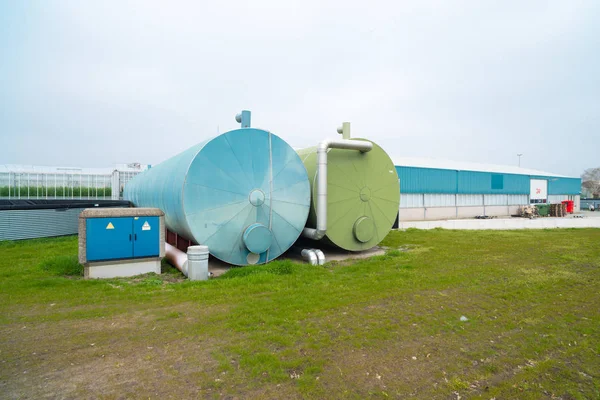 Tanques líquidos junto a un invernadero Fotos de stock libres de derechos