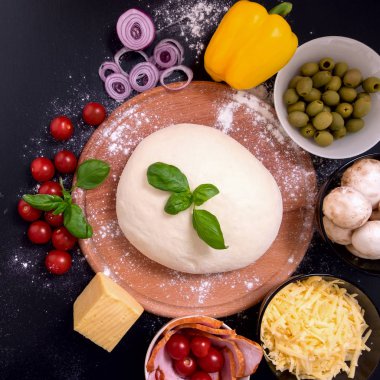 Siyah bir zemin üzerine pizza et sebze ve baharatlar ile. Üstten görünüm