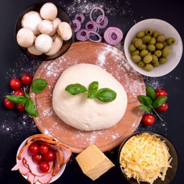 Siyah bir zemin üzerine pizza et sebze ve baharatlar ile. Üstten görünüm