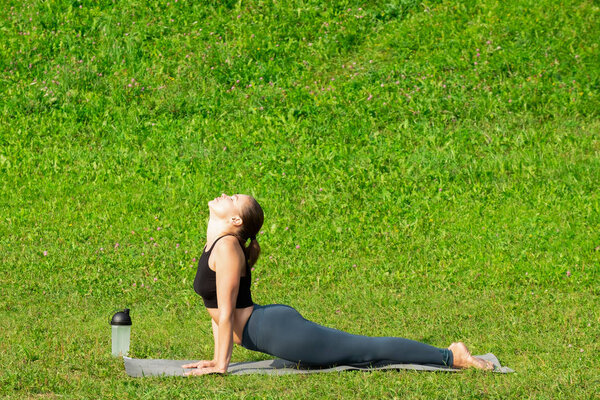 Woman on a yoga, relax in the park.