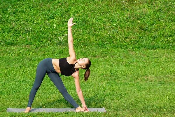 Mujer en un yoga, relajarse en el parque . — Foto de Stock