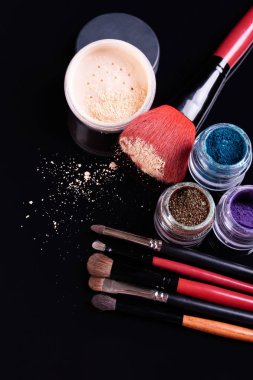 Siyah bir backgr üzerinde makyaj için profesyonel kozmetik ve fırçalar