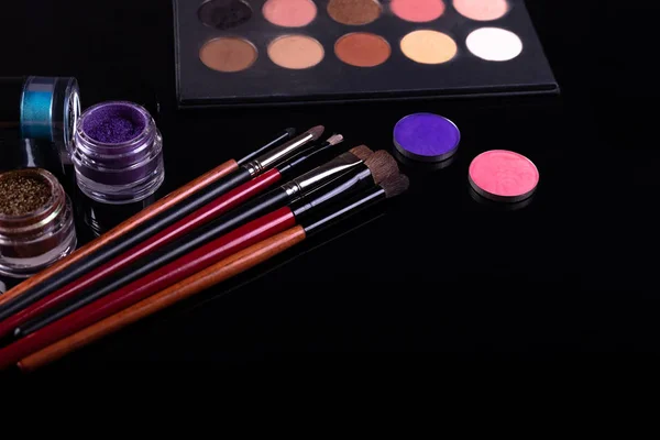 Professional cosmetics and brushes for make-up on a black backgr — Stock Photo, Image