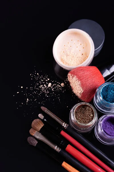 Cosmétiques et pinceaux professionnels pour maquillage sur fond noir — Photo