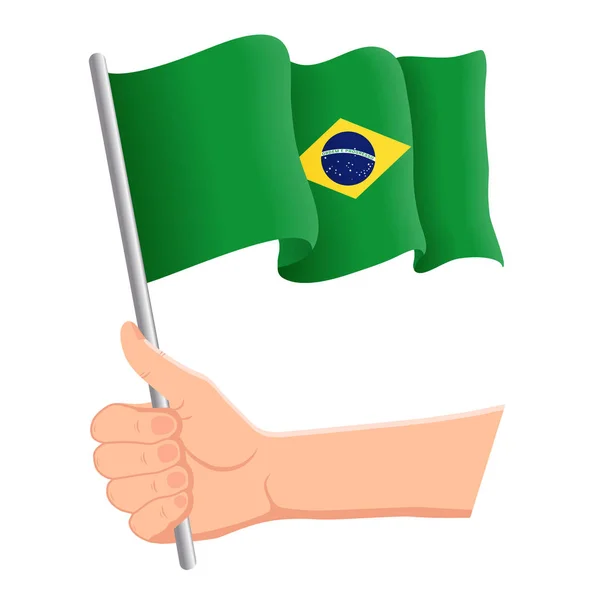Hand haltend und die brasilianische Nationalflagge schwenkend. Fans, Unabhängigkeitstag, patriotisches Konzept. Vektorillustration — Stockvektor