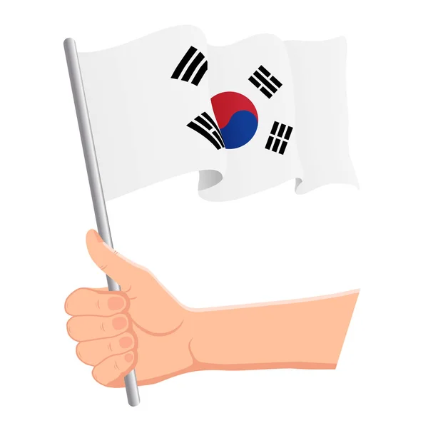 Mano sosteniendo y ondeando la bandera nacional de Corea del Sur. Aficionados, día de la independencia, concepto patriótico. Ilustración vectorial — Archivo Imágenes Vectoriales