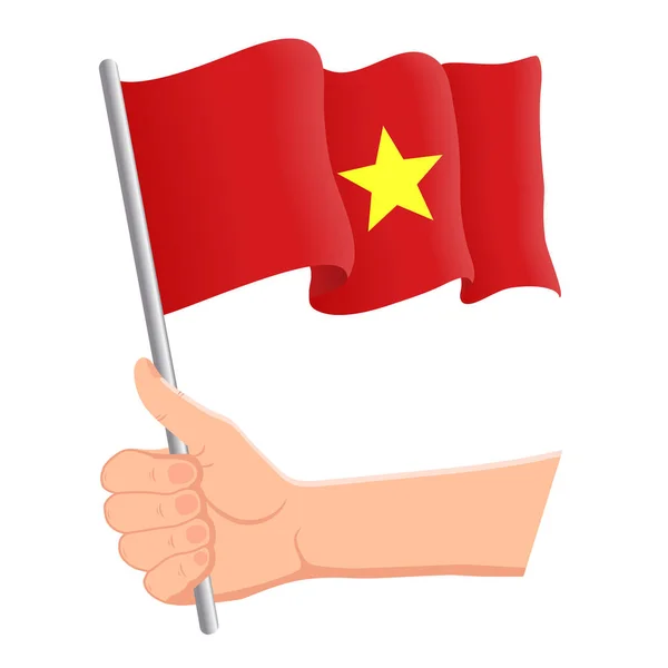 Main tenant et agitant le drapeau national du Vietnam. Eventails, fête de l'indépendance, concept patriotique. Illustration vectorielle — Image vectorielle