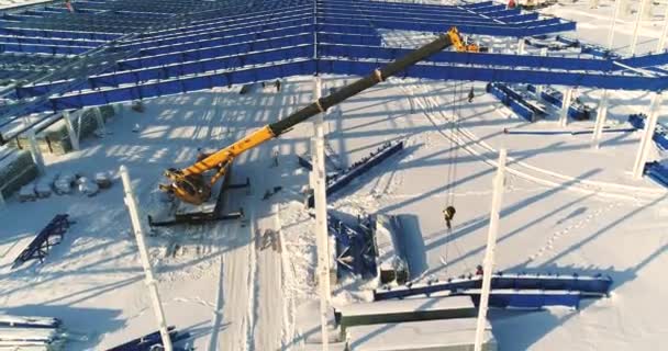 Construção de uma fábrica ou planta moderna, área industrial no inverno, vista panorâmica do ar. Planta moderna no campo coberto de neve, a estrutura de aço estrutural de um novo edifício comercial — Vídeo de Stock