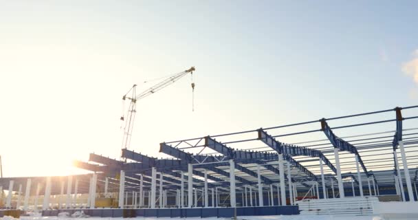 Armazém moderno canteiro de obras, a estrutura de aço estrutural de um novo edifício comercial contra um céu azul claro no fundo, Construção de uma fábrica moderna ou armazém — Vídeo de Stock