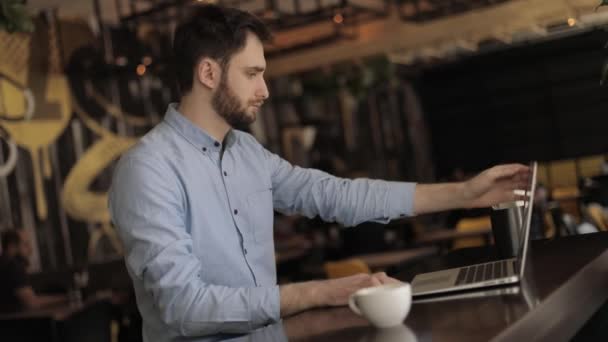 Бизнесмен с ноутбуком в кафе или ресторане, привлекательный работник-мужчина использует компьютер в кафетерии — стоковое видео