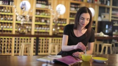 Aroma ve lezzet kahve kahve dükkanında dinlenirken zevk genç kız ile bir fincan sıcak kahve ya da çay, bir restoranda. Genç güzel mutlu gülümseyen kız kupa sıcak kahve veya çay ile tutarak