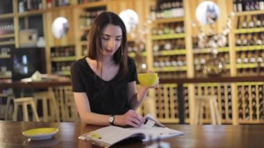 Aroma ve lezzet kahve kahve dükkanında dinlenirken zevk genç kız ile bir bardak çay, bir restoranda. Genç güzel mutlu gülümseyen kız kupa sıcak çay ile tutarak