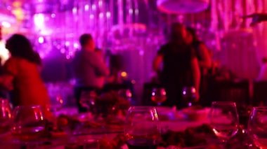 Bir restoran veya bir gece kulübü, alkol ve gıda siluetleri dans insanlar, sahne ışık ve mor dolgu, sığ alan derinliği arka planı ziyafet tablolarla bir gençlik partisi