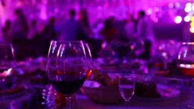 Bir restoran veya bir gece kulübü, alkol ve gıda siluetleri dans insanlar, sahne ışık ve mor dolgu, sığ alan derinliği arka planı ziyafet tablolarla bir gençlik partisi