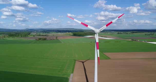 Vista aérea da turbina eólica, Uma vista do gerador de vento no fundo de panoramas de campos verdes e prados, ao redor, energia eólica na agricultura — Vídeo de Stock