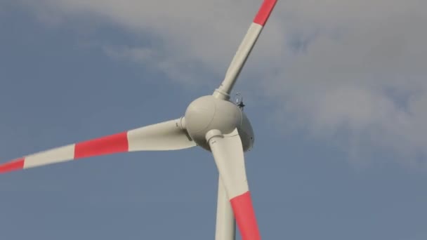 Turbina eólica close-up contra o fundo de nuvens flutuando no céu. Rotação de pás de turbinas eólicas grandes — Vídeo de Stock