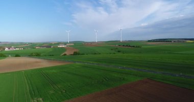 Tarım alanlarından ve rüzgar jeneratörlerinden oluşan hava panoramaları elektrik üretiyor. Alternatif rüzgar enerjisi elde etmek için modern teknolojiler. Hava görünümü