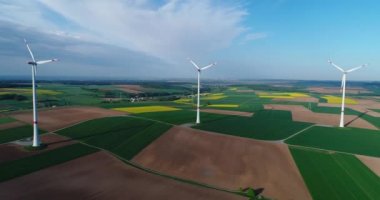 Tarım alanlarından ve rüzgar jeneratörlerinden oluşan hava panoramaları elektrik üretiyor. Alternatif rüzgar enerjisi elde etmek için modern teknolojiler. Hava görünümü