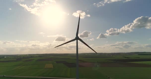 Вид з повітря на вітрову турбіну, Вид на вітрогенератор на тлі панорам зелених полів і лугів навколо, вітроенергетика в сільському господарстві — стокове відео