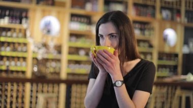 Aroma ve lezzet kahve kahve dükkanında dinlenirken zevk genç kız ile bir bardak çay, bir restoranda. Genç güzel mutlu gülümseyen kız kupa sıcak çay ile tutarak