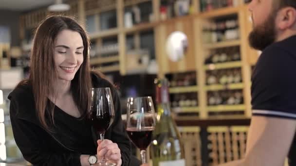 Chica joven en un restaurante con una taza de café caliente, disfrutando del aroma y el sabor del café mientras se relaja en la cafetería. Joven hermosa chica sonriente feliz sosteniendo taza con café caliente o té — Vídeos de Stock