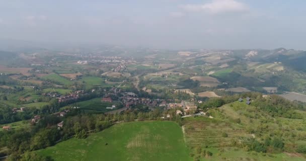 Eine kleine stadt in einem tal zwischen grünen hügeln, ein blick von oben, luft, panorama aus der luft, panorama, europa, italien — Stockvideo