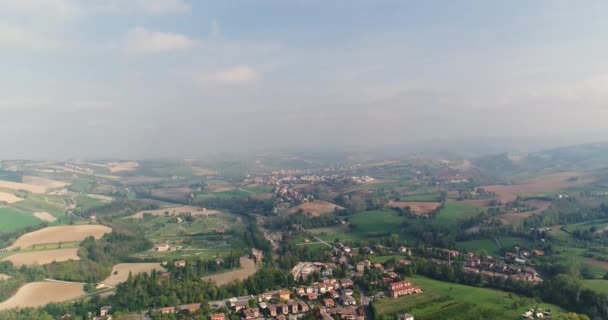 ヒルズ、イタリアの小さな中世の町、パノラマ ビュー、上記からの眺め、茶色の屋根の家の間の谷に小さなイタリアの町の空撮 — ストック動画