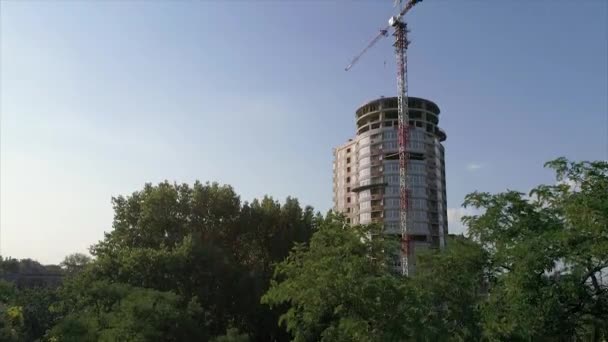 Bau eines mehrstöckigen Hochhauses, ein Turmdrehkran auf einer Baustelle, ein Blick auf den Bau eines modernen Hochhauses, eine städtische Landschaft — Stockvideo