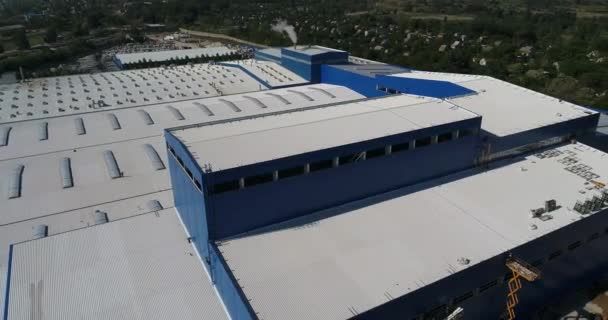 Den ljusa byggnadskroppen är en modern fabrik från luften, en vit-blå byggnaden av en stor fabrik, moderna fabriker från ovan — Stockvideo