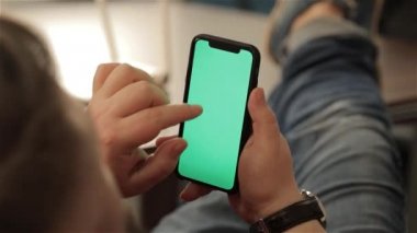 Genç adam akıllı telefon kullanarak evden çalışan adamın iç, onun işyerinde teknolojisiyle, hromakey adam akıllı telefon kullanarak eller
