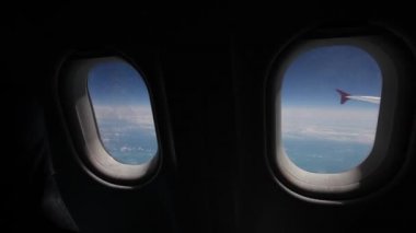 Mavi gökyüzü ve bulutlar uçak pencereden görünümünü yakın uçak pencere uçak kanadı, hareket kavramı ile